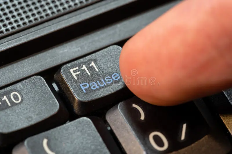 A man pressing F11 on keyboard